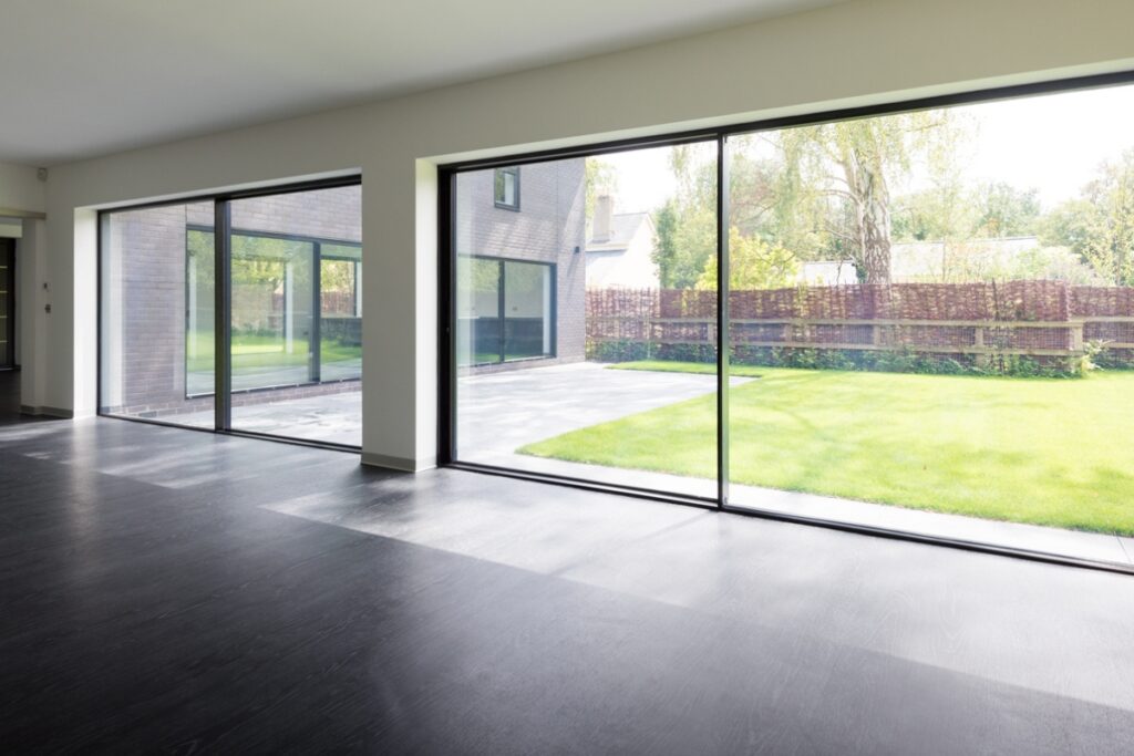 Origin slimline aluminium sliding doors opening onto a modern garden, combining thermal efficiency with minimal design.