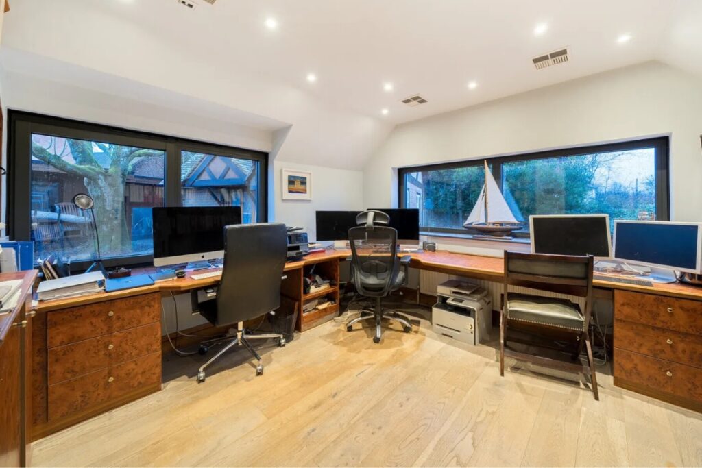 Dining room with exposed beams and slim-framed bi-fold doors to the garden in a Chilterns home