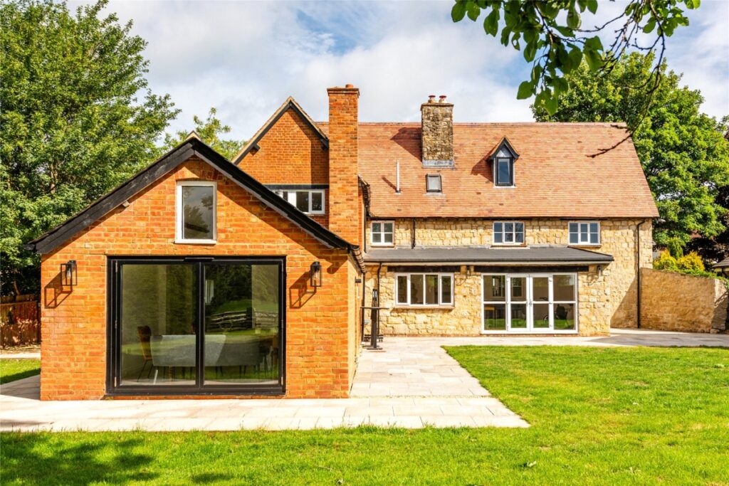 Windows and doors Oxfordshire - white casement windows and dark aluminium sliding doors on a stone and brick home